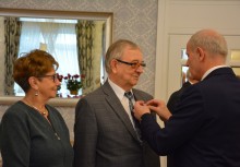 Burmistrz wpina medal jednemu z jubilatów