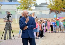 Sołtys Tuchomia przemawia, w tle dzieci - powiększ