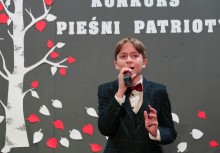 Chłopiec przy mikrofonie podczas konkursu - powiększ