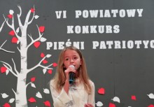 Dziewczynka przy mikrofonie podczas konkursu - powiększ