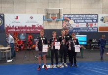 Na zdjęciu trener oraz czterech zawodników z medalami - powiększ