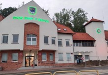 Budynek Urzędu Gminy w Żukowie. Herb, napis 'Gmina Żukowo' oraz zegar są podświetlone na zielono