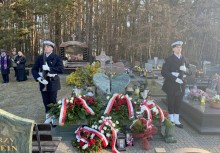 Dwóch żołnierzy z Marynarki Wojennej RP stojących przy pomniku adm. Andrzeja Karwety. W tle las. 