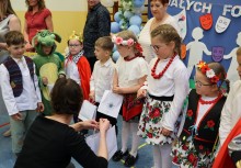 Kobieta wręcza paczki upominkowe dzieciom.  - powiększ