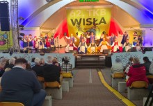 Tłum ludzi siedzący na scenie podziwiający występ artystów na scenie. - powiększ