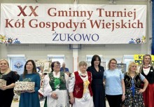8 kobiet na tle banneru o Zawodach Kół Gospodyń Wiejskich