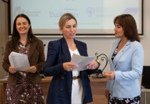 Trzy kobiety. Kobieta po środku czyta trzymany w rękach dokument.  - powiększ