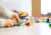 Konkurs Kaszubski LEGO Mistrz - klocki LEGO, ręce osoby budującej z klocków LEGO. - powiększ