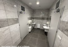 Na zdjęciu widać pomieszczenie wyłożone szarymi kafelkami, trzy umywalki i pomieszczenia - powiększ