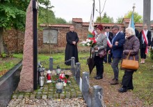 Przed mogiłą stoją przedstawiciele Koła Związków Kombatantów RP i WP w Żukowie. W tle kilka osób - powiększ