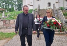 Ksiądz i kobieta idą z kwiatami