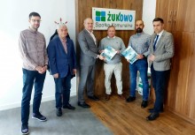 Sześć osób, w tle logo Spółki Komunalnej Żukowo - powiększ