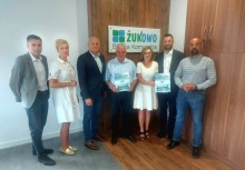 7 osób, w tle logo Spółki Komunalnej Żukowo - powiększ