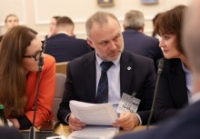 Trzy osoby rozmawiają przy stole konferencyjnym.  - powiększ