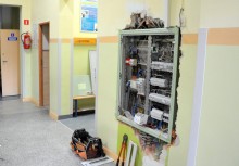 Otwarta skrzynka elektryczna w ścianie budynku szkoły w Pępowie - powiększ