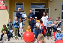 Burmistrz składa gratulacje dyrektor szkoły w Glinczu przed budynkiem. Na schodach dzieci. - powiększ