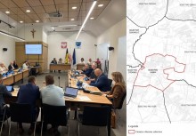 Obrady Rady Miejskiej – radni przy stole, w tle ekran i symbole gminy. Obok mapa z zaznaczonym nowym obwodem. - powiększ