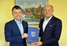 Nowe nawierzchnie asfaltowe w Tuchomiu i w Borkowie - podpisanie umowy - Pan Burmistrz Wojciech Kankowski z wykonawcą, teczka z umową