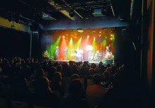 7 muzyków na scenie, przed nimi publiczność - powiększ