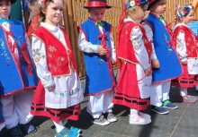 Dzieci z przedszkola w Miszewie ustawione w szeregu podczas występu z okazji Święta Konstytucji 3 Maja – ubrane w kolorowe kaszubskie stroje ludowe, z uśmiechami i dziecięcą energią. - powiększ