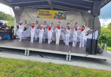 Grupka dzieci występujących na scenie ubranych na biało . - powiększ