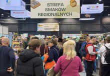 Na zdjęciu duża grupa osób odwiedzająca Festiwal Smaków Regionalnych. Nad nimi wisi duży transparent z napisem 'Strefa Smaków Regionalnych'.  - powiększ