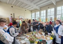 Zdjęcie stołu z potrawami Wielkanocnymi. W tle ludzie. - powiększ