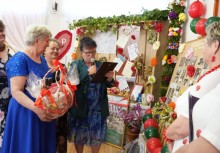 Na zdjęciu sześć kobiet. Jedna z nich trzyma kosz prezentowy w dłoniach, druga kobieta przemawia. - powiększ