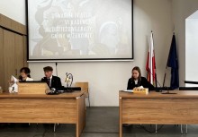 Na zdjęciu troje przedstawicieli Młodzieżowej Rady Gminy. W tle widać rzutnik z napisem 'OTWARCIE IV SESJI VI KADENCI MŁODZIEŻOWEJ RADY GMINY W ŻUKOWIE'.