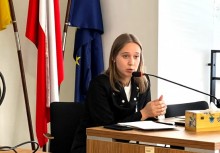 Na zdjęciu dziewczyna przemawiająca do mikrofonu.  - powiększ