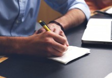 Mężczyzna notujący coś przy biurku