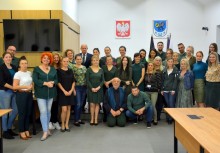 Około 30 osób, w tym burmistrz i urzędnicy, są w sali obrad Rady Miejskiej w urzędzie Gminy w Żukowie. Każda osoba ma na sobie zielony element garderoby. - powiększ